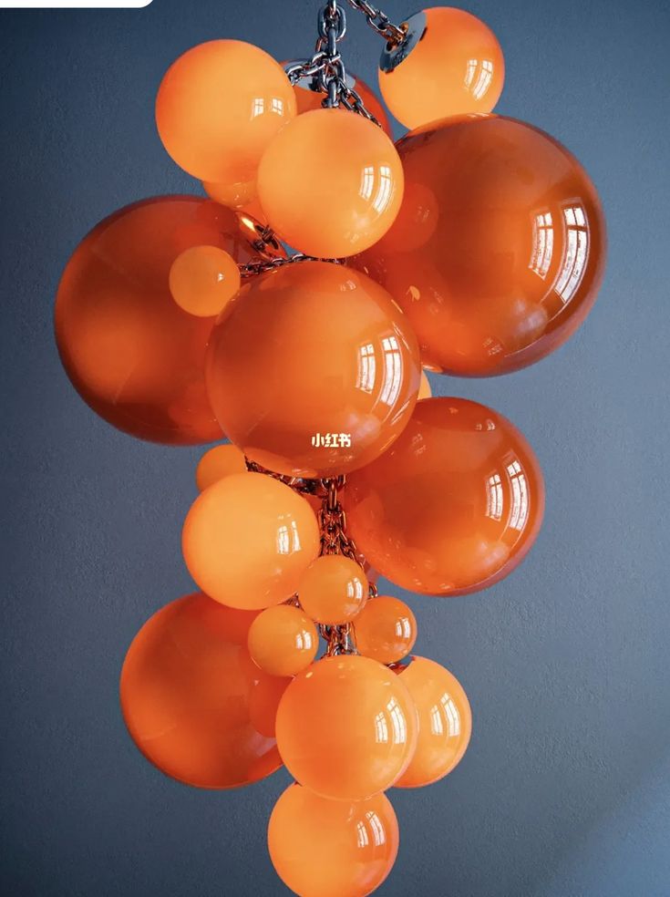 a bunch of orange balloons hanging from a chain