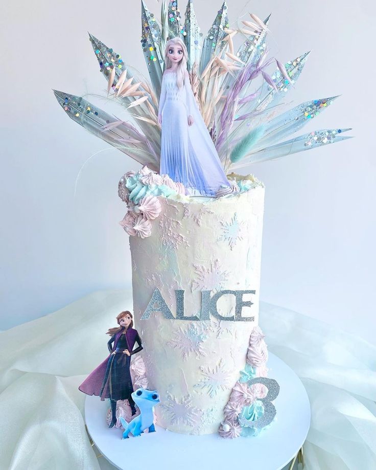 there is a cake with frosting and decorations on the top that has an ice queen figure in it