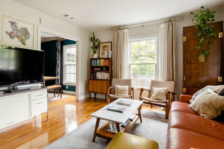 a living room filled with furniture and a flat screen tv on top of a wooden table