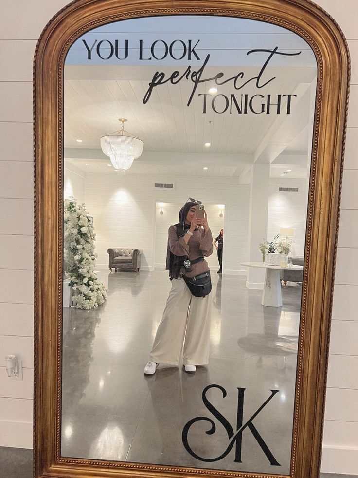 a woman taking a selfie in front of a mirror that says, you look perfect tonight