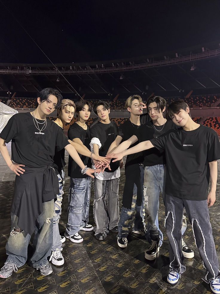 a group of young men standing next to each other in front of an empty stadium