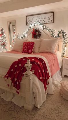 a bedroom decorated for christmas with red and white decorations on the bed, wreaths and lights