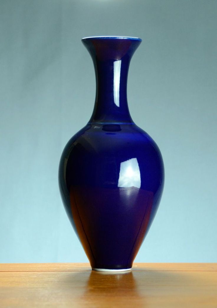 a blue vase sitting on top of a wooden table