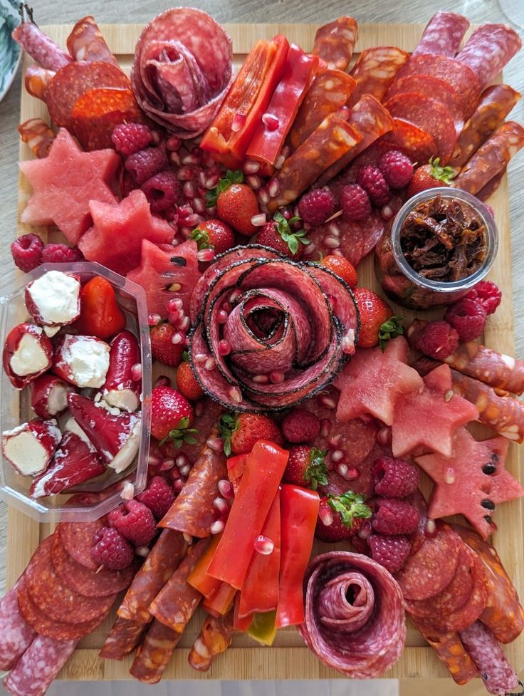 a wooden cutting board topped with lots of meat and veggies on top of it