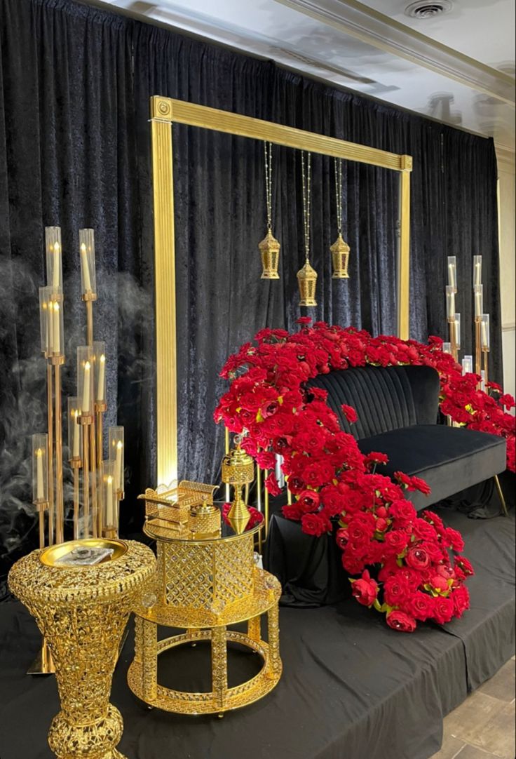 a black and gold wedding set up with red flowers