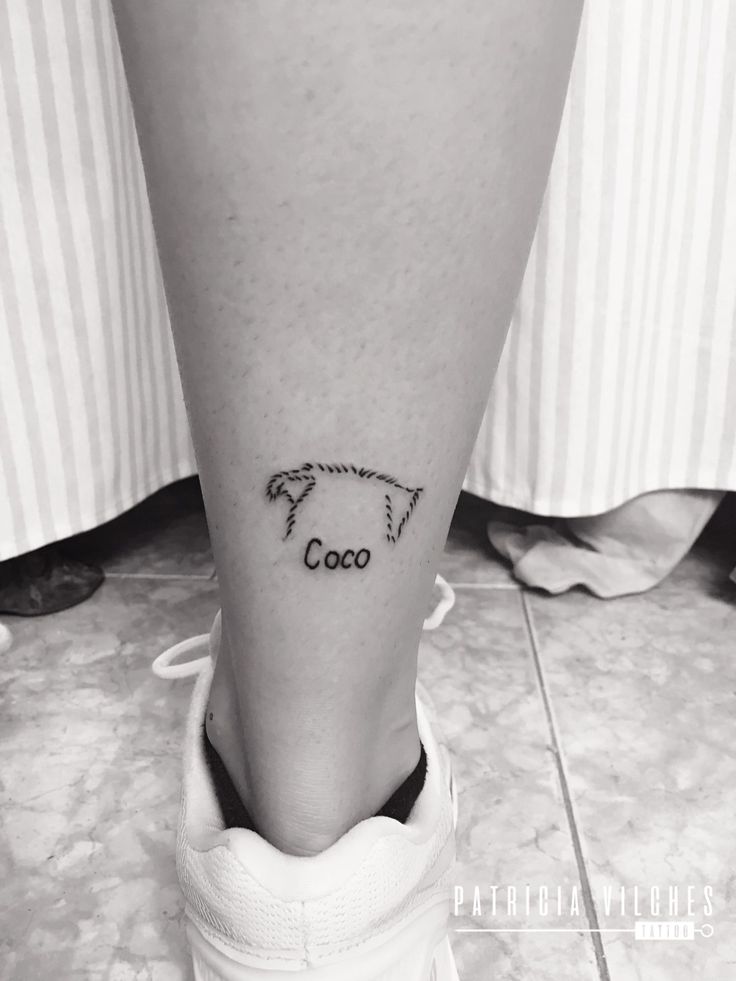 a person with a small tattoo on their leg that reads coco and has a pig in it