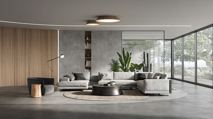 a modern living room with concrete walls and large plants in the corner, along with a round coffee table