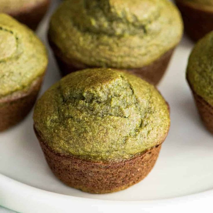 several green muffins are on a white plate