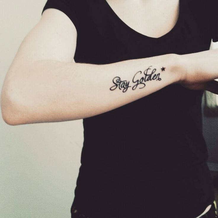 a woman with a tattoo on her arm that says stay golden in black ink and stars