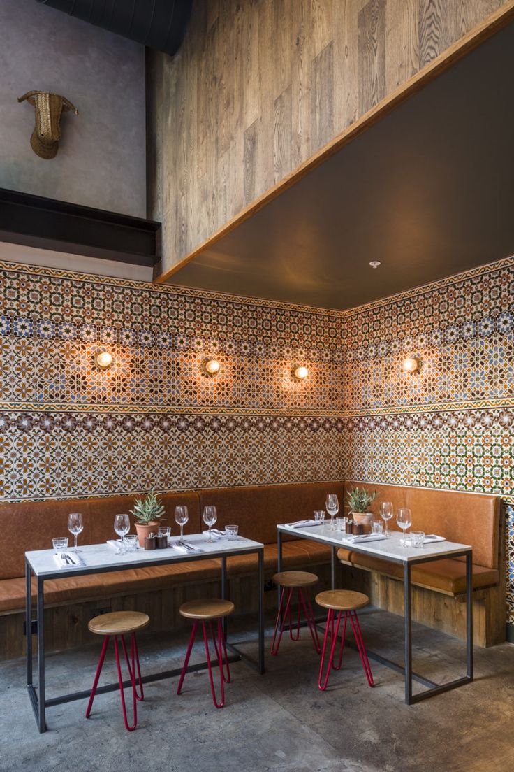 an empty restaurant with tables and benches in the center, along with wallpaper on the walls