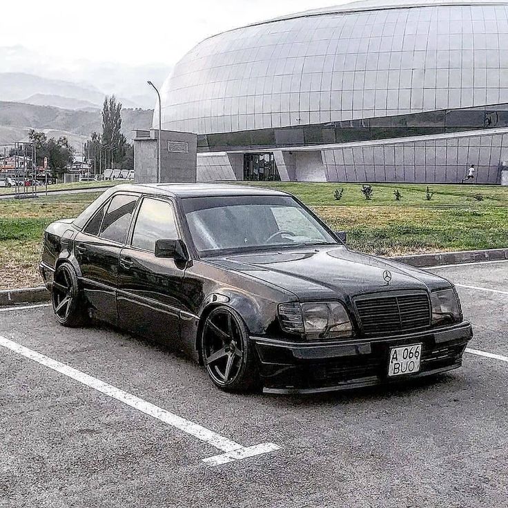 a black car parked in a parking lot next to a building