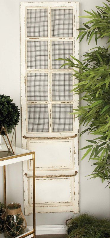 an old white door is next to a potted plant