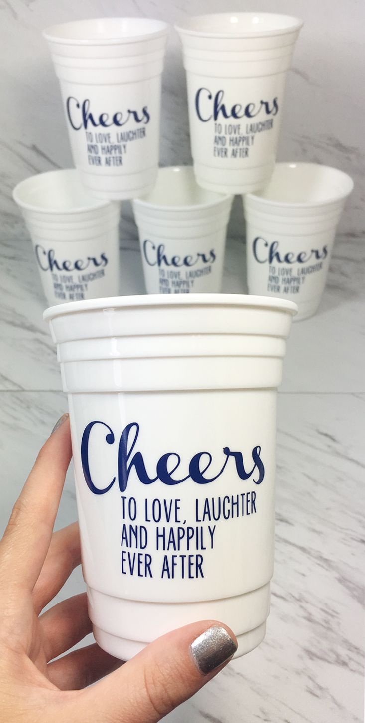 a person holding up a cup that says cheers to love laughter and happily ever after