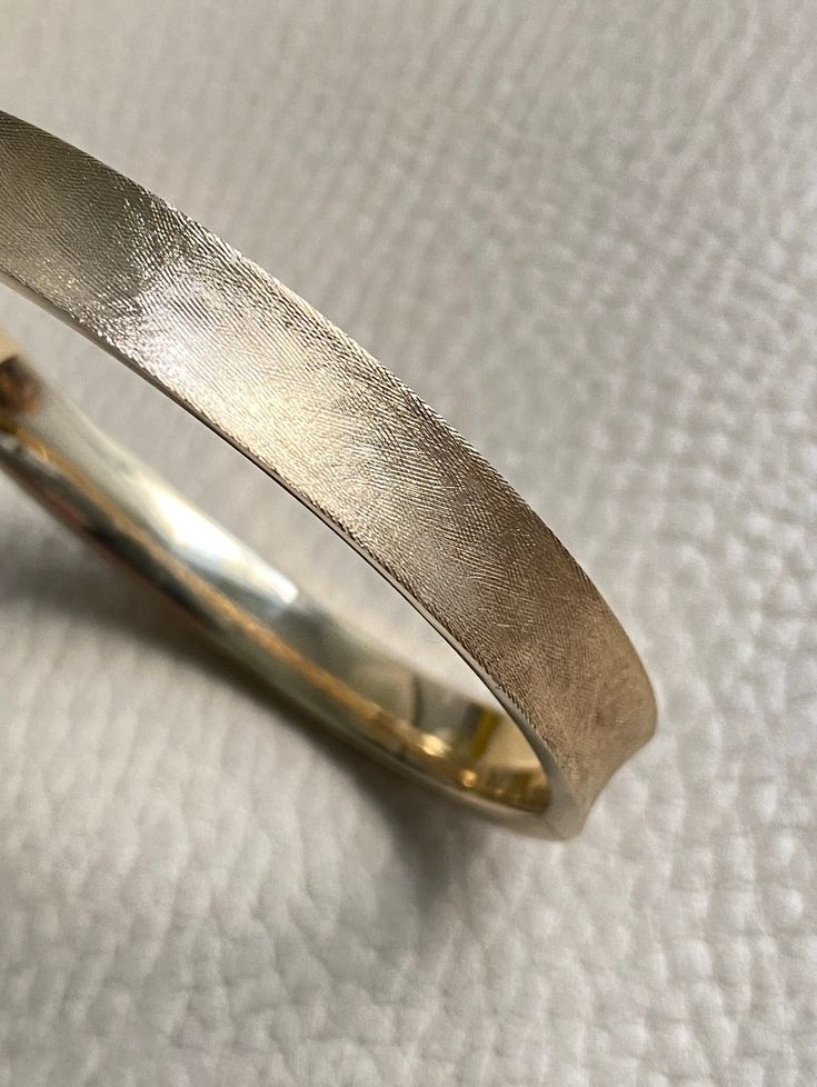 A beauty! 14k gold textured hinged bangle bracelet - 6.9 inch interior A beautiful vintage hollow-form bangle bracelet in 14k gold. She has a concave exterior that has been hand finished with a sublime cross-hatch texture. Bangle interior has a high polish for comfort and visual contrast. *** Details 12.1g 14k gold (not fill or plated) Interior oval measures 2 inches (52mm) x 2.4 inches (60mm) 6.9 inch interior size approximate Hallmark with 14k inside heart outline 8mm wide Well working clasp w Vintage Gold Necklace, Hollow Form, Heart Outline, Hinged Bangle, Gold Texture, Leather Jewelry, Ring Bracelet, Bangle Bracelet, Vintage Gold