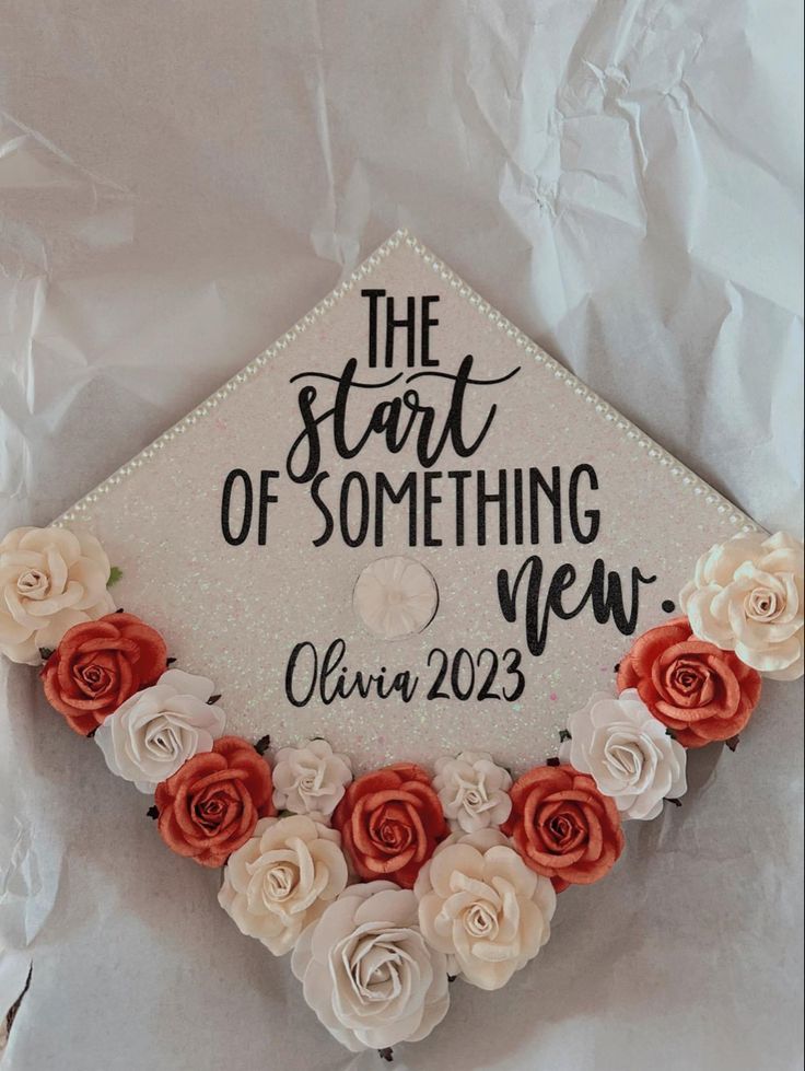 a graduation cap decorated with flowers and the words, the start of something new