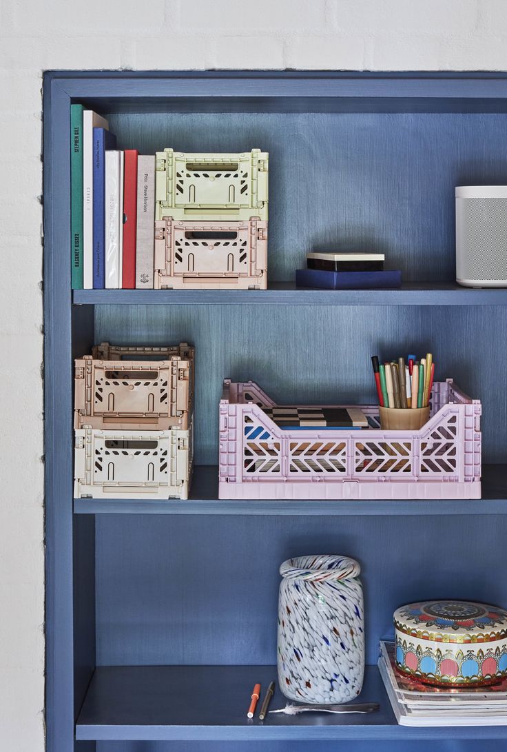 a blue book shelf filled with lots of books and knick - knacks