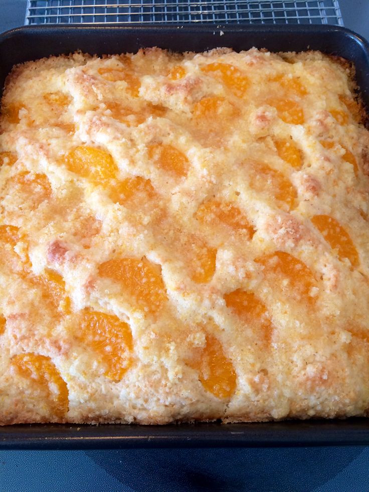 an orange cake in a black pan on a blue table