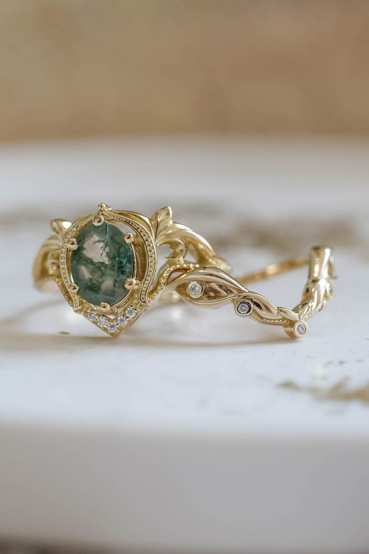 a close up of a gold ring with a green stone in it's center