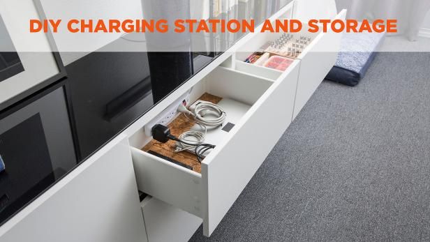 an open drawer in the side of a white cabinet next to a black stove top oven