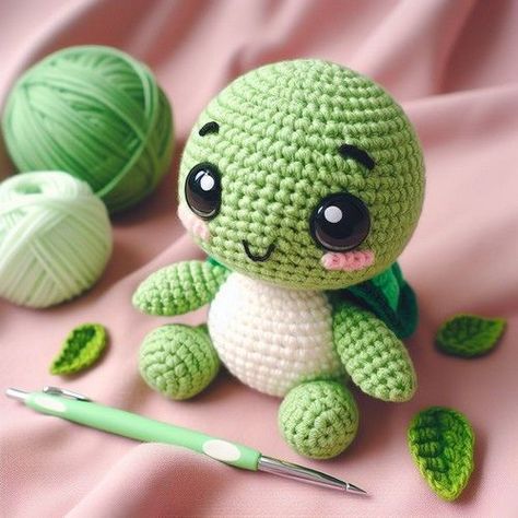 a crocheted turtle sitting next to two balls of yarn and a ball of knitting needles