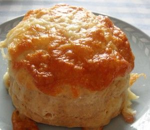 a close up of a plate of food with cheese and sauce on it, sitting on a table