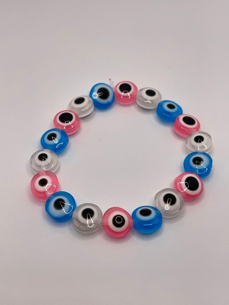 A cool multi-colored eye bead bracelet. Includes blue, pink, and clear beads. Multicolor Beaded Bracelet With Evil Eye, Pink Adjustable Evil Eye Bracelet Trendy, Adjustable Pink Evil Eye Trendy Bracelet, Multicolor Evil Eye Round Bracelets, Multicolor Round Evil Eye Bracelets, Pink Beaded Evil Eye Bracelet, Pink Beaded Evil Eye Bracelet With Round Beads, Trendy Multicolor Beaded Evil Eye Bracelet, Casual Multicolor Beaded Evil Eye Bracelet