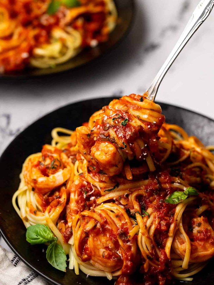 a plate of spaghetti with shrimp and tomato sauce