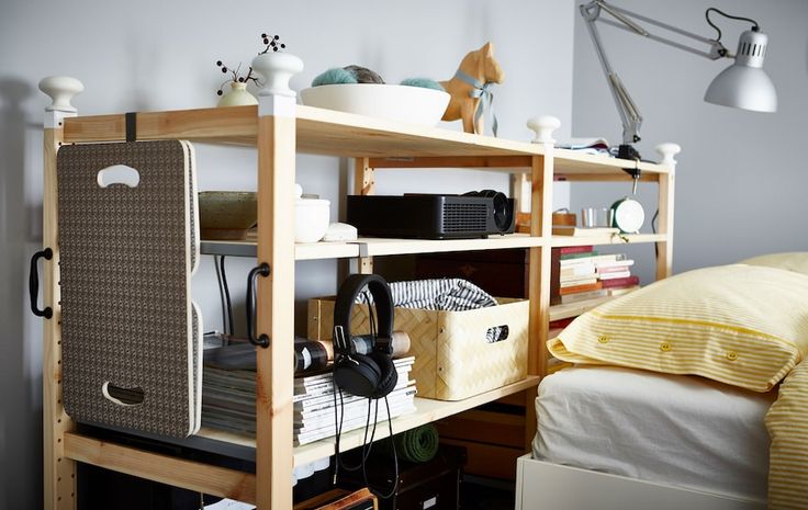 a bed room with a neatly made bed and a book shelf next to the bed