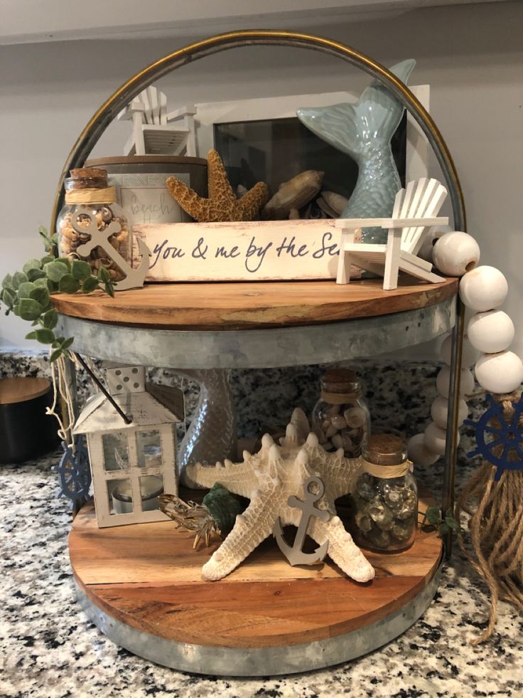 three tiered shelf with shells and other items on it in a kitchen countertop