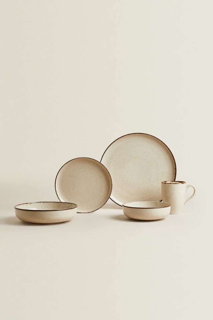 three plates and two cups on a white surface