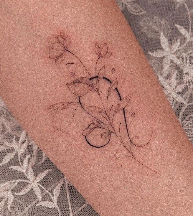 a woman's arm with flowers and stars on it