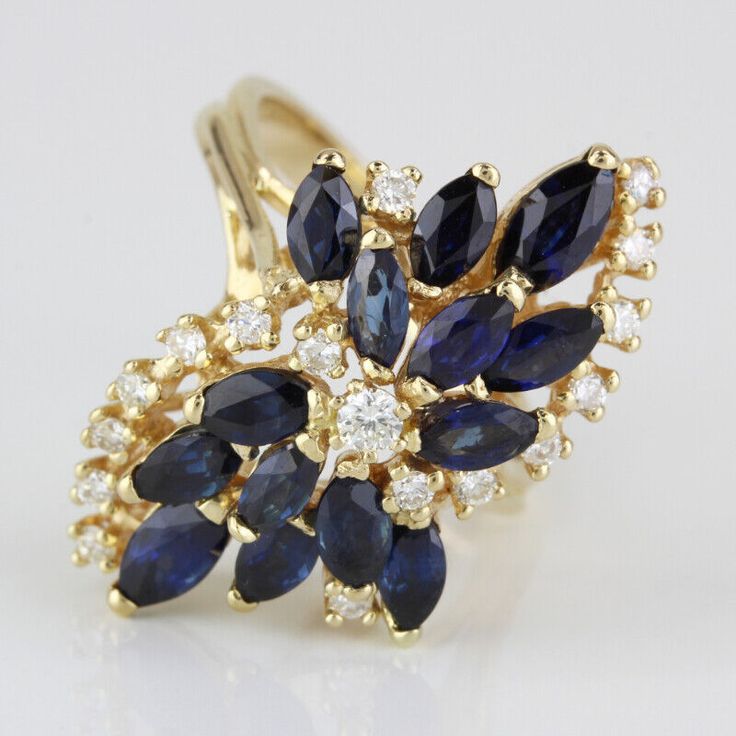 Vintage 14K Yellow Gold Blue Sapphire & Diamond Anniversary Cocktail Ring This Vintage cocktail ring is made of 14 karat yellow gold & has 14 Marquise-cut Sapphires and 17 Round-cut Diamonds placed into a large floral / waterfall-like setting, making for a truly unique and impressive accessory! The band is a size 6 but can be resized by any qualified jeweler. "14KY" is stamped onto the inside part of band, as well. Size: 6 (resizable) // 2.2-2.7mm band width Metal: 14 Karat Yellow Gold Weight: 3 Vintage Cocktail Ring, Blue Sapphire Diamond, Diamond Anniversary, Vintage Cocktail, Marquise Cut, Sapphire Diamond, Cocktail Ring, Round Cut Diamond, Womens Jewelry Rings