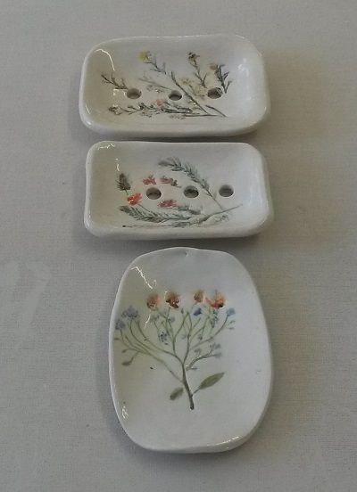 three white dishes with flowers painted on them