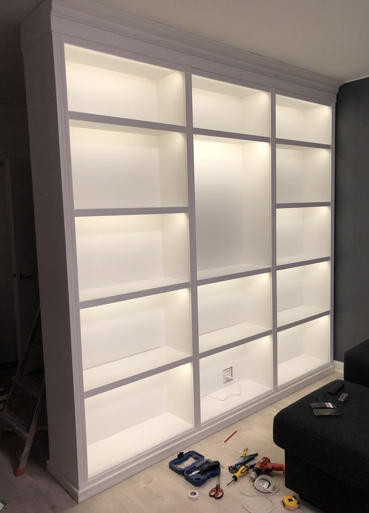 a white bookcase with lights on it in a room that is being remodeled and remodeled