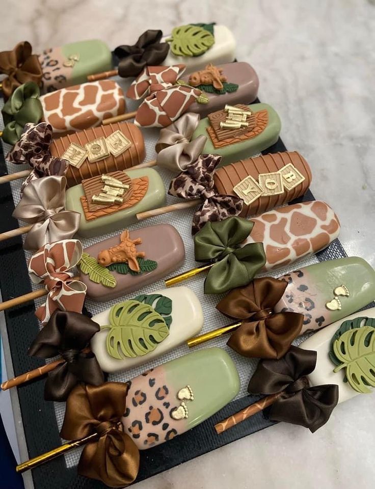 many different types of decorated lollipops with bows on them sitting on a table