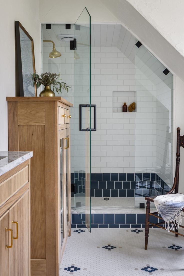 a bathroom with blue and white tiles on the floor, shower stall and sink area