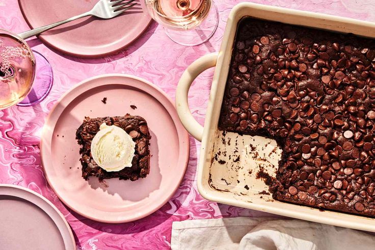 a table topped with pink plates and desserts