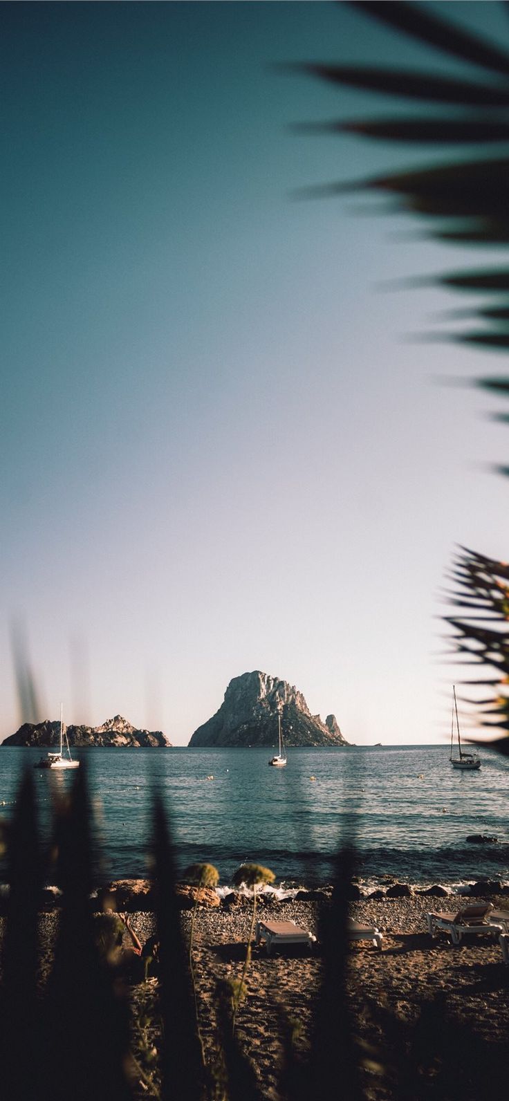 an island in the distance with boats out on the water