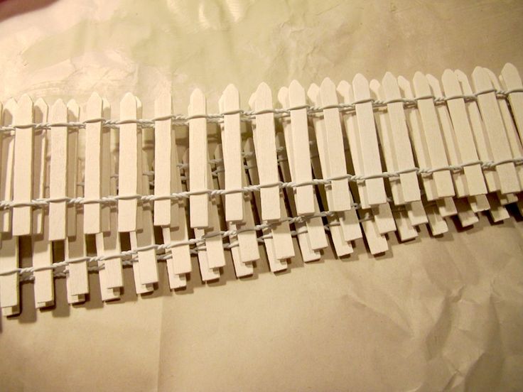 a close up of a white fence made out of wood and metal bars on a sheet of paper