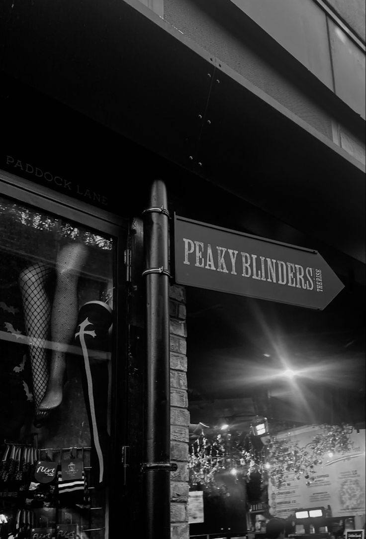 a black and white photo of a pole with a sign that says peaky blinds