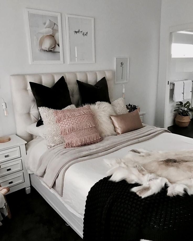 a white bed topped with lots of pillows and blankets