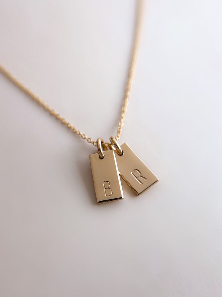 "Handmade Tiny Tag Necklace ✨   18k Gold Filled 💫 Hand Stamped Handstamped with the your choice of personalization with initials. 🌟  Handmade with 18k gold filled tiny tags on an 18k gold filled fully adjustable (up to 17.5\") dainty chain. Each individual letter is handstamped onto the gold filled tiny tags.  Hypo allergenic, lead free, nickel free.  Each piece is handmade in my home studio in Brookings, SD. Comes in Mandy Ellen Designs gift packaging with a polishing cloth included." Couple Necklace Aesthetic, Minimalist Charm Necklace Adjustable Length For Gift, Dainty Gold Resizable Necklaces, Resizable Gold Jewelry As A Gift, Adjustable 14k Gold Filled Necklace For Anniversary, Adjustable Initial Pendant Jewelry Gift For Her, Gold Resizable Everyday Necklaces, Everyday Resizable Gold Necklaces, Minimalist Necklace With Adjustable Length For Gift