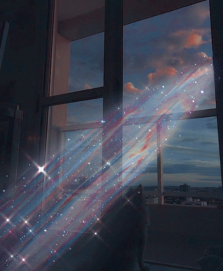 a person standing in front of a window looking out at the sky with stars on it