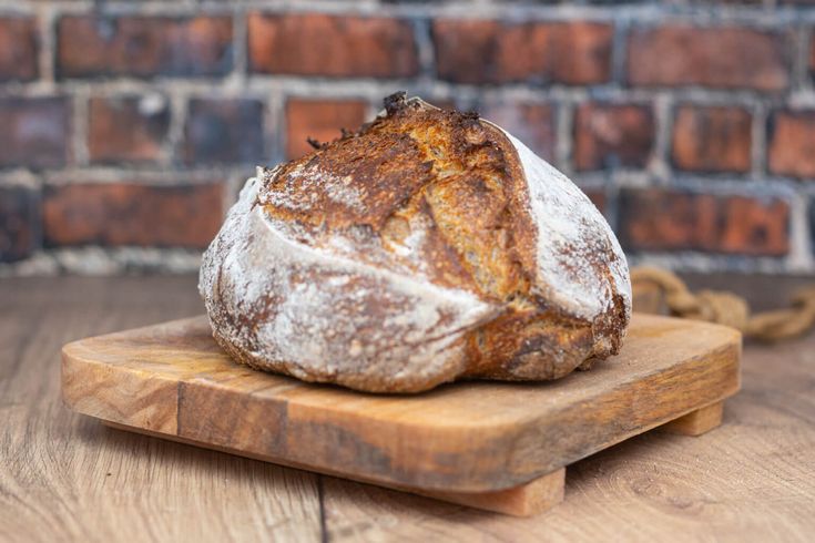 a loaf of bread sitting on top of a wooden cutting board