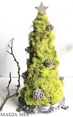 a moss covered christmas tree sitting on top of a table