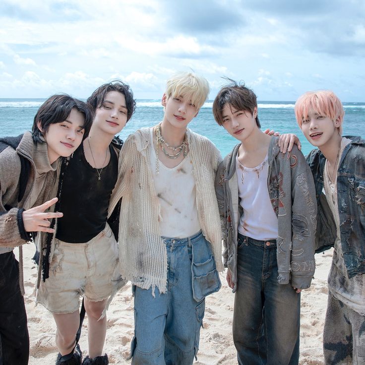 four young men posing for a photo on the beach