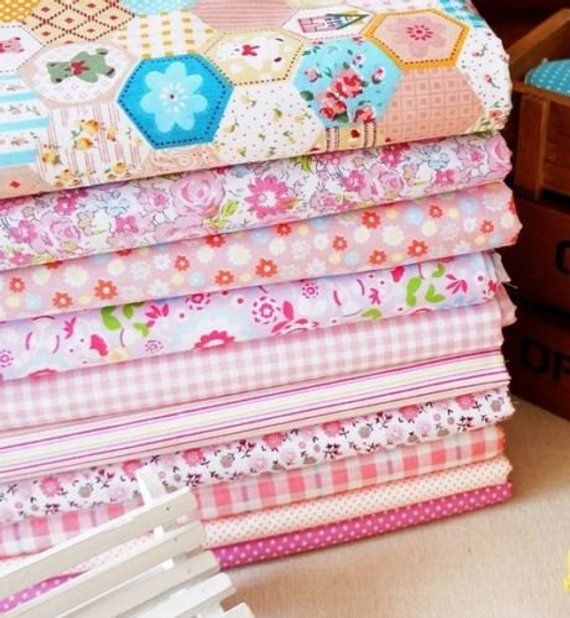 a stack of colorful fabrics sitting on top of a table next to flowers and boxes