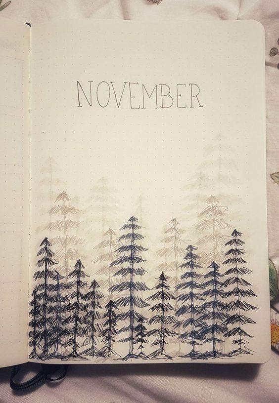 an open notebook with the words november written on it and pine trees drawn in ink