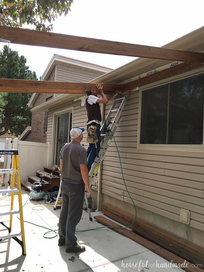 two men are working on the roof of a house while another man is repairing it