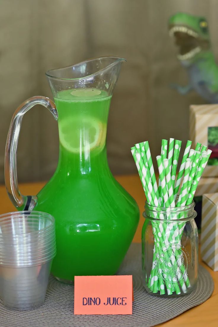 there is a green pitcher and some straws on the table